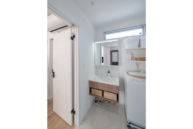 キッチンからすぐにアクセスできる洗面室。床は大理石調のデザインでホテルのような雰囲気に。<br />
