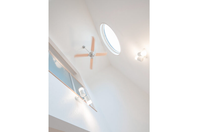 天井のファンが、床暖房で暖まった1 階の空気を室内全体に行き渡らせる。