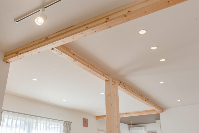 構造梁をあらわしにして天井を高く。白い天井に木目の優しいアクセント。