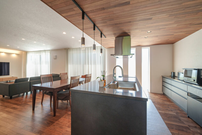 大きな掃き出し窓が印象的なLDK。T 邸は横に長い形になっており、LDK に奥行きがある。床材にはブラックウォールナットを採用。