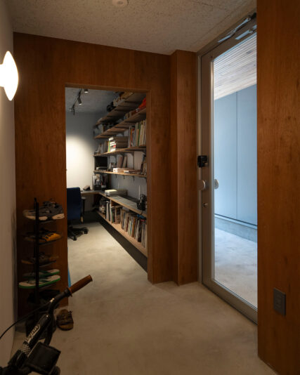 玄関ドアに向かう土間。無機質な素材感と天井の木の風合いのギャップが美しい。