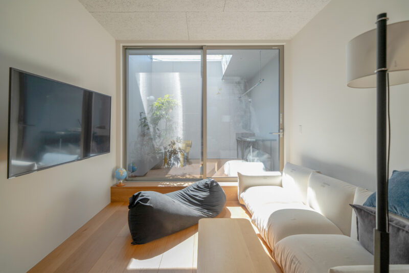 隣家との距離が近い、都市の暮らし。外に対してはほとんど窓はなく、天窓とバルコニーから光を入れる設計。昼間は照明無しでも十分に明るい。