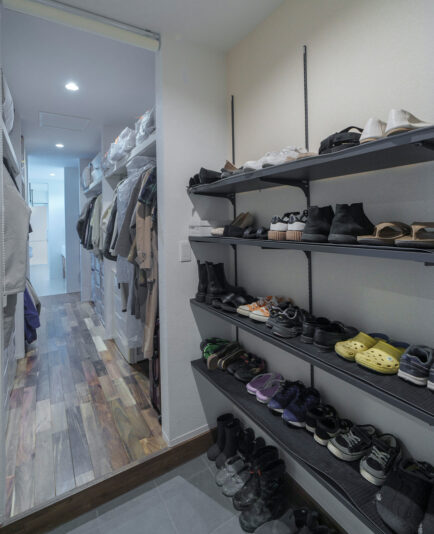 玄関からつながるウォークスルーのファミリークローク。子どもたちがきちんと整理できるように、ランドセル専用の収納棚も造作した。