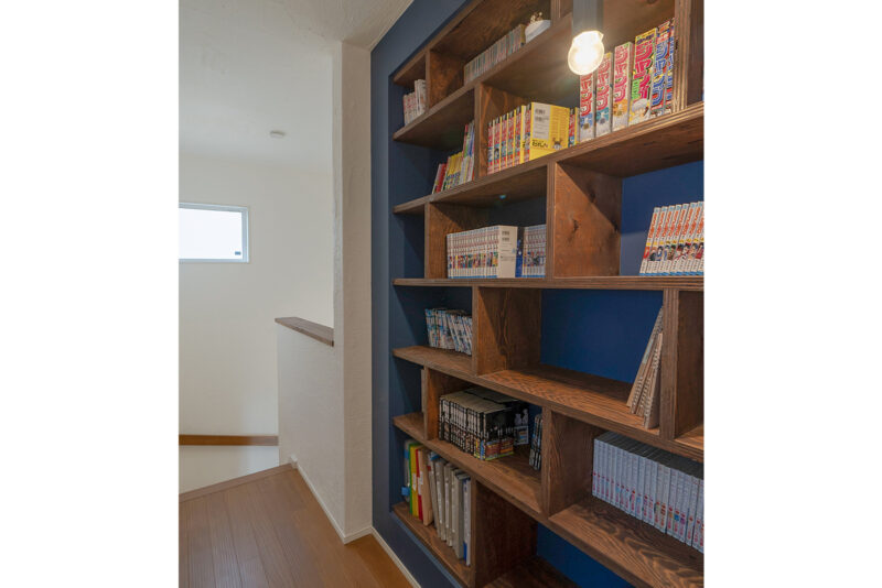 階段を上がった廊下部分に本棚を造作。圧迫感をなくすために壁に掘り込む形とした。<br />
