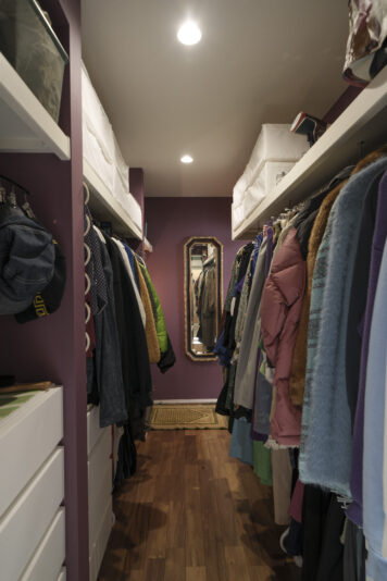 ウォークスルー収納。マゼンタ色の壁紙や大きなアンティークの鏡が、セレクトショップのような雰囲気を醸し出している。
