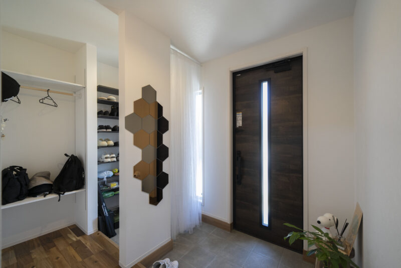 お客さま用と家族用で分けた玄関。ヘキサゴンデザインのウォールミラーがアクセントに。