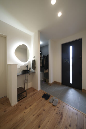 トイレ横の手洗いスペース。ミラーの間接照明やハニカム柄のタイルなど、こだわりの空間。