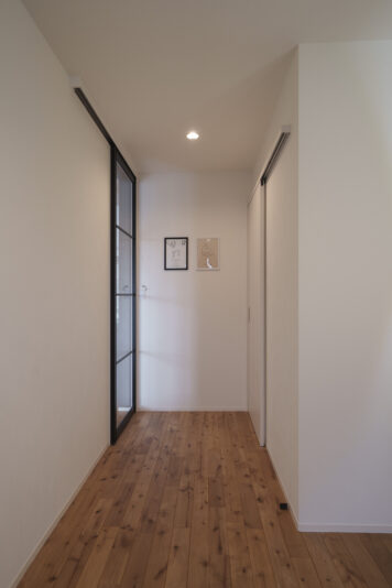 玄関とリビングをつなぐ引戸はブラックフレームのシースルータイプに。リビングと玄関がつながって広い空間に。