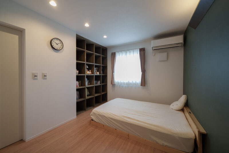 天井の高さまで収納できる棚を造作した寝室。奥さまの愛読書がスッキリと収納できる。