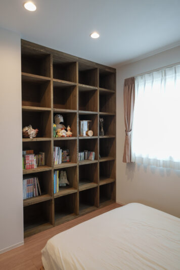 天井の高さまで収納できる棚を造作した寝室。奥さまの愛読書がスッキリと収納できる。