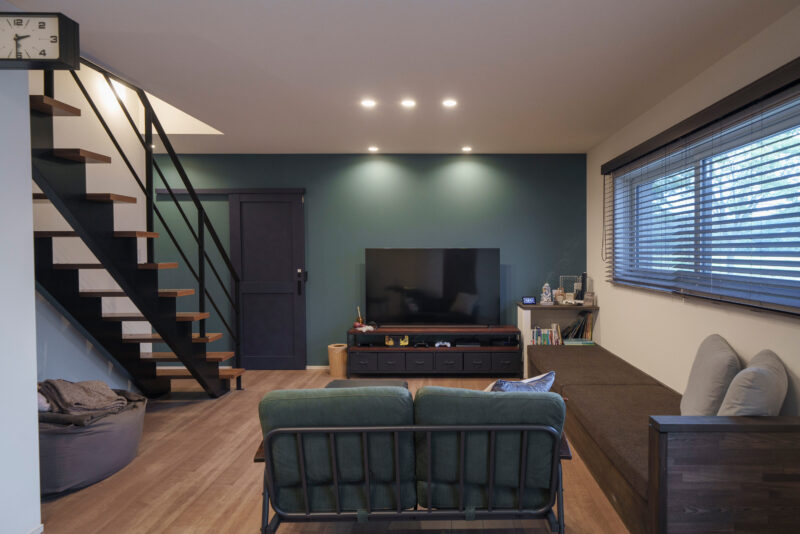 モスグリーンの壁紙が印象的なリビング。