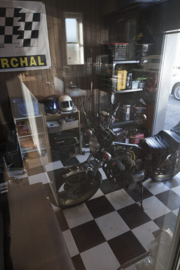 ご主人念願のビルトインガレージ、床の市松模様のシートはご主人自ら施工。愛車はKAWASAKI のZ-400J。「高校生の頃からバイクが好きで。時間があればいじっています。リビングからもバイクが見えるのが最高！」とご主人。